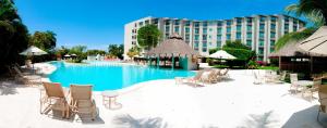 uma piscina com cadeiras e um hotel ao fundo em Gamma Plaza Ixtapa em Ixtapa