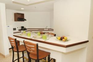 a kitchen with a island with a table with fruit on it at Gamma Plaza Ixtapa in Ixtapa