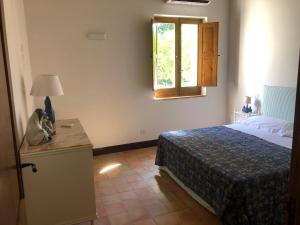 a bedroom with a bed and a window at La Casa del carrubo di Borgo Carbone in Locri