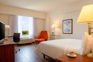 a hotel room with a bed and a desk and a chair at Fiesta Inn Tampico in Tampico