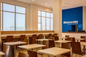 a classroom with tables and chairs and a sign that reads benzriento at One Chihuahua Fashion Mall in Chihuahua
