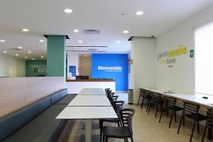 une salle à manger avec des tables et des chaises dans un restaurant dans l'établissement One Queretaro Centro Sur, à Querétaro