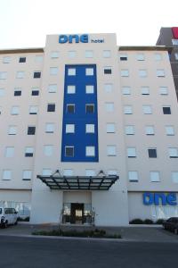 un bâtiment d'hôpital dmg avec un panneau bleu dans l'établissement One Queretaro Centro Sur, à Querétaro