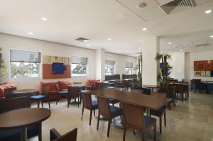 a restaurant with tables and chairs in a room at One Puebla FINSA in Puebla