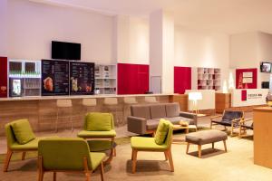 モレリアにあるFiesta Inn Morelia Altozanoの椅子とソファ付きの待合室