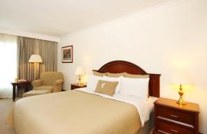 une chambre d'hôtel avec un lit et une chaise dans l'établissement Fiesta Inn Nuevo Laredo, à Nuevo Laredo