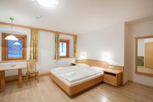 a bedroom with a bed and a table and a desk at Hotel Kammerhof in Mariastein