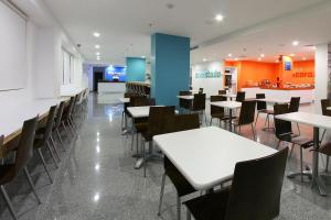 a dining room with tables and chairs and a counter at One Guadalajara Periferico Poniente in Guadalajara