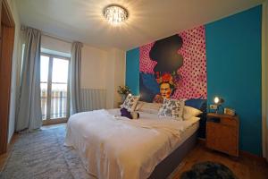 a bedroom with a large bed with a colorful wall at Design Residence Del Passo in Padola