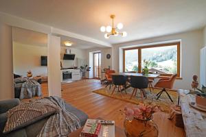 a living room with a table and a dining room at Design Residence Del Passo in Padola