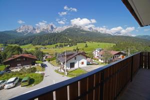 a balcony with a view of a village and mountains at Design Residence Del Passo in Padola