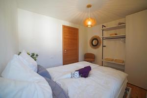 a bedroom with a white bed with a pillow on it at Design Residence Del Passo in Padola