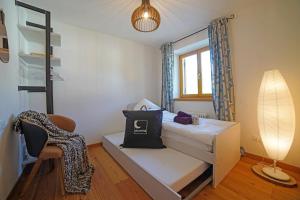 a small bedroom with a bed and a chair at Design Residence Del Passo in Padola