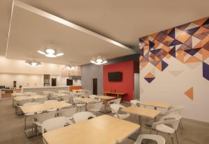 une salle de classe avec des tables et des chaises et un mur coloré dans l'établissement Fiesta Inn Express Monterrey Centro, à Monterrey