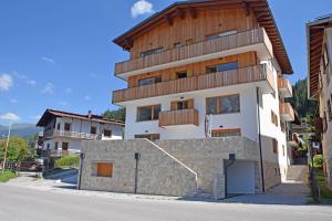 a white building with a wooden roof at Design Residence Del Passo in Padola