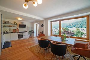 a living room with a table and a large window at Design Residence Del Passo in Padola