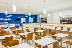 eine leere Cafeteria mit Tischen und Stühlen in der Unterkunft One Mexicali in Mexicali