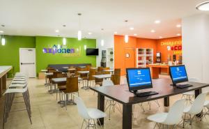 ein Restaurant mit Tischen und Stühlen, auf denen Laptops stehen in der Unterkunft One Mexicali in Mexicali