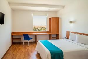 ein Schlafzimmer mit Bett, Schreibtisch und Fenster in der Unterkunft One Mexicali in Mexicali + 54 Fotos