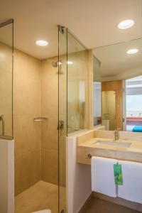 een badkamer met een glazen douche en een wastafel bij One Mexicali in Mexicali