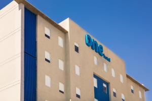 ein Gebäude mit einem blauen Schild an der Seite in der Unterkunft One Mexicali in Mexicali