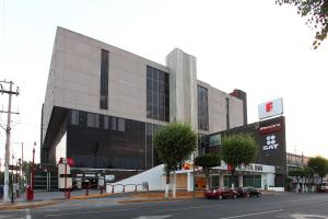 ein Gebäude auf einer Straße mit davor geparkt in der Unterkunft Fiesta Inn Tlalnepantla in Mexiko-Stadt