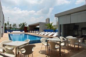 a patio with tables and chairs next to a pool at One Villahermosa 2000 in Villahermosa