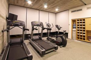 un gimnasio con tres máquinas de correr en una habitación en One Villahermosa 2000, en Villahermosa