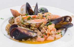 a plate of food with seafood and rice on a plate at La Vigna Hotel in Bonea