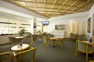 a restaurant with tables and chairs and a television at Fiesta Inn Ciudad del Carmen in Ciudad del Carmen