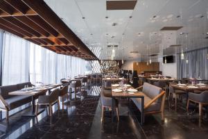 a dining room with tables and chairs and windows at Grand Fiesta Americana Monterrey Valle in Monterrey