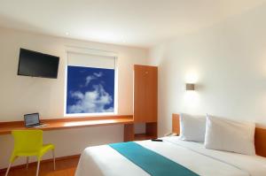 1 dormitorio con cama, escritorio y ventana en One Monclova en Monclova