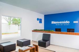una sala de espera con 2 sillas y una señal azul en One Monclova en Monclova