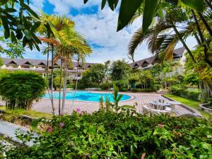 an image of a resort swimming pool with palm trees at Sila Pool Villa in Chiang Mai