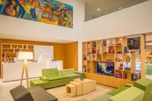 ein Wohnzimmer mit grünen Möbeln und einem TV in der Unterkunft Fiesta Inn Monterrey la Fe in Monterrey