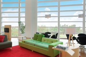 a living room with a green couch and chairs at Fiesta Inn Puebla Las Animas in Puebla