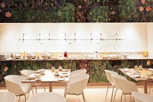 a dining room with tables and white chairs at Fiesta Inn Puebla Las Animas in Puebla