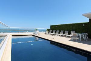 - une piscine avec des chaises et une table dans un bâtiment dans l'établissement One La Paz, à La Paz