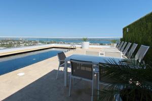 a patio with a table and chairs next to a swimming pool at One La Paz in La Paz