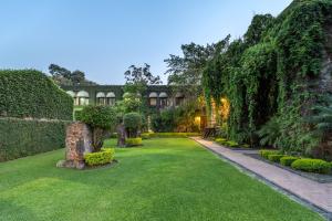 an exterior view of a garden with trees and grass at Fiesta Americana Hacienda San Antonio El Puente Resort & Spa in Cuernavaca