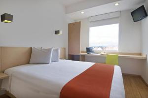 a bedroom with a large bed and a window at One Toluca Aeropuerto in Toluca
