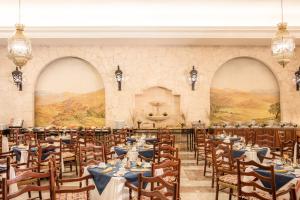 a banquet hall with tables and chairs and a mural at Gamma Merida El Castellano in Mérida