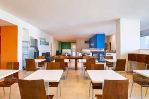 una sala da pranzo vuota con tavoli e sedie di One Puerto Vallarta Aeropuerto a Puerto Vallarta