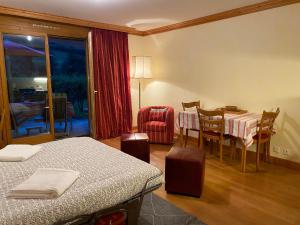 Cette chambre comprend deux lits, une table et des chaises. dans l'établissement Studio - La Vièze Thermes Park, à Val dʼIlliez