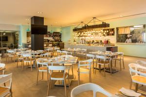 ein Restaurant mit Tischen und Stühlen und eine Bar in der Unterkunft Fiesta Inn Express Ciudad de México Forum Buenavista in Mexiko-Stadt + 28 Fotos