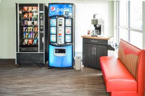 una macchina Pepsi in camera con un refrigeratore per bevande di GREELEY UNIVERSITY INN/ GREELEY INN a Greeley