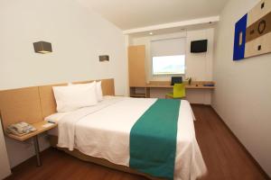 1 dormitorio con cama, escritorio y ventana en One Saltillo Derramadero, en La Encantada