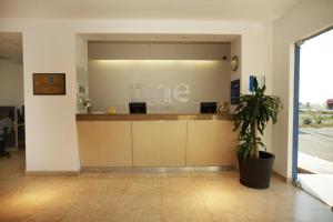 een lobby met een balie in een kantoor met een plant bij One Saltillo Derramadero in La Encantada