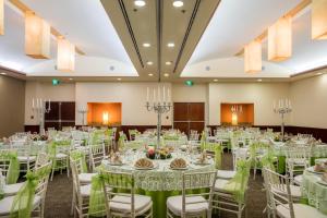 - une salle de banquet avec des tables et des chaises blanches dans l'établissement Fiesta Inn Tuxtla Gutierrez, à Tuxtla Gutiérrez