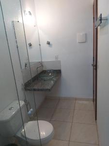 a bathroom with a toilet and a sink at Pousada Capim Dourado in Alto Paraíso de Goiás